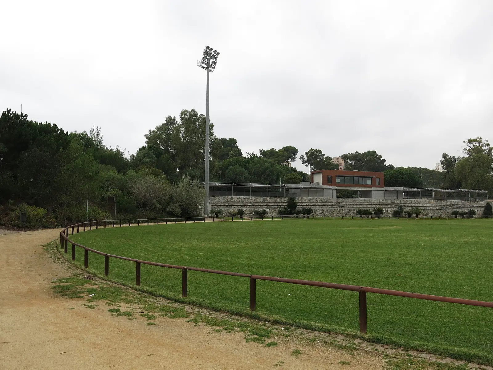 Grass arena with fence and trees at the Hipodromo Manuel Possolo in Cascais