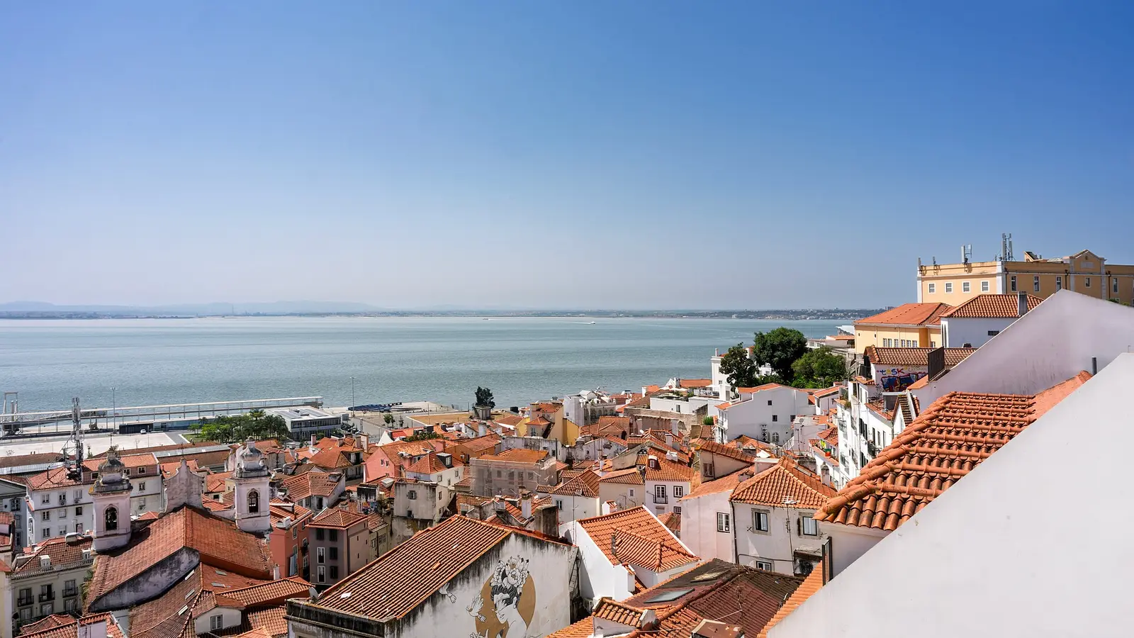 Alfama rooftops and the Tagus river seen from a Lisbon viewpoint