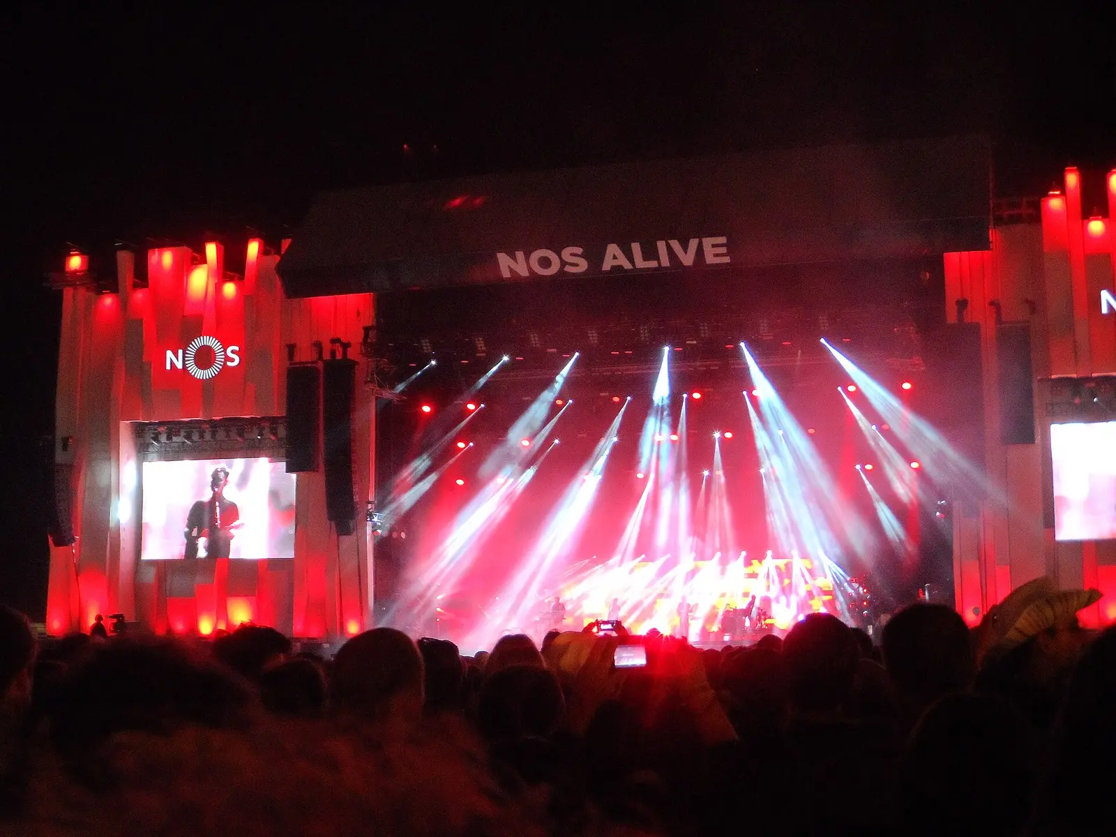 Crowd facing a lit main stage at NOS Alive festival in Algés