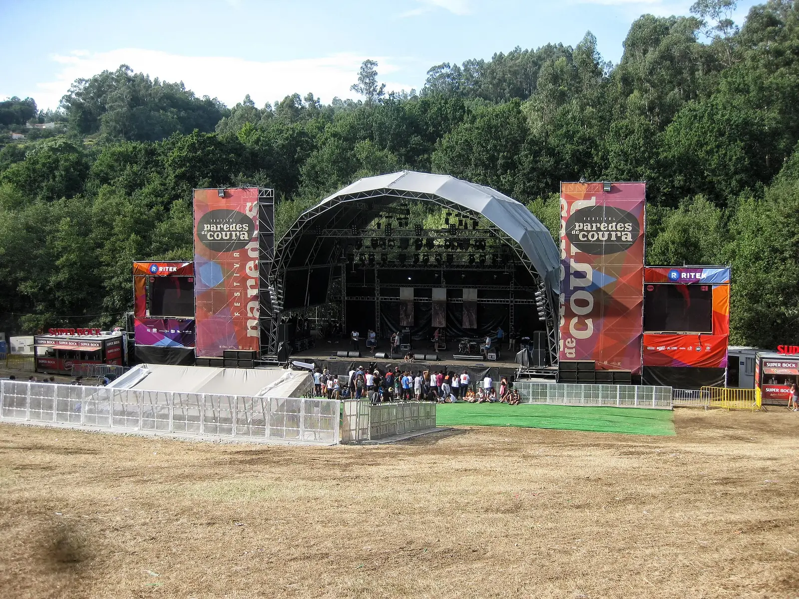 Main stage of the Paredes de Coura festival among wooded hills above the river beach