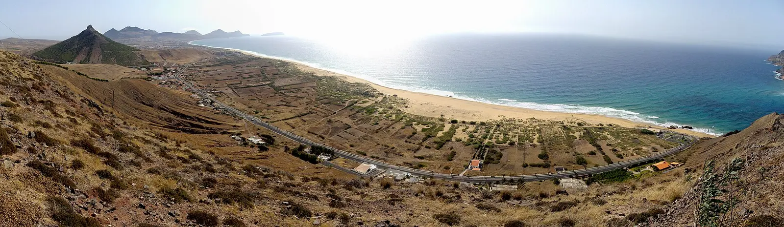 Panorama of the Porto Santo coast with a long sandy beach and dry hillside fields